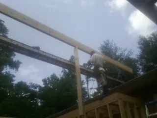 Carpenter setting a ridge beam over a new addition frame — Ice Dam Removal by Roofing Brothers in Fort Harrison