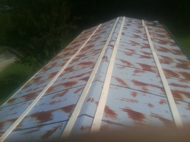 Rusted metal roof panels with new wood purlins before replacement — Storm Damage Roof Repair in Fort Harrison by Roofing Brothers