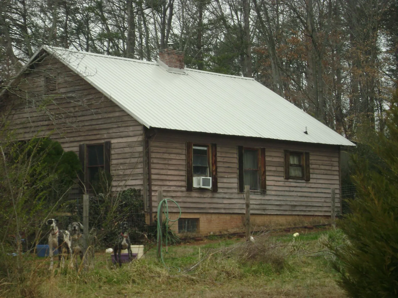 White metal roof on an old wood sided farmhouse, from a Metal Roof Installation job in Fort Harrison